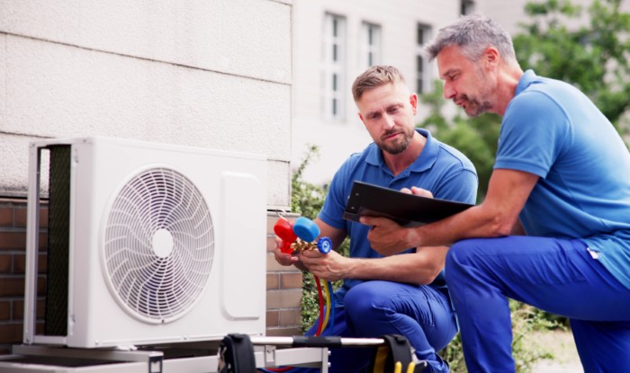 HVAC technicians reviewing an outdoor air conditioning unit in Bullhead City, AZ