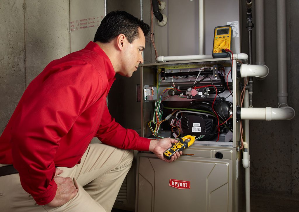 Heating and air conditioning technician servicing an indoor furnace in Bullhead City, AZ