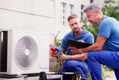 ac-installation-in-claremont-ca HVAC technicians reviewing an outdoor air conditioning unit in Bullhead City, AZ