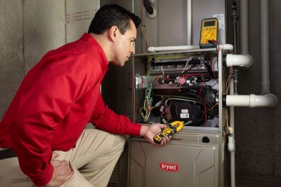 furnace repair Heating and air conditioning technician servicing an indoor furnace in Bullhead City, AZ